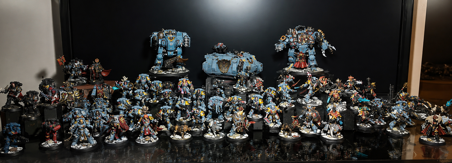 Collection of miniature figurines on a reflective surface with a dark background